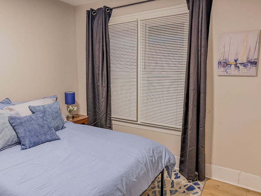 Second bedroom with cozy bedding and window light.