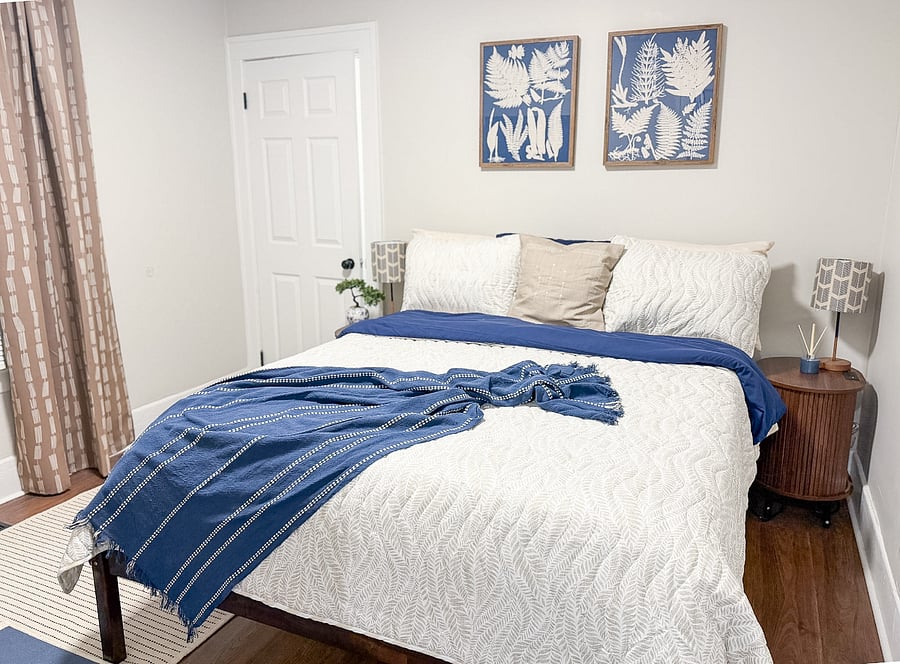 Spacious primary bedroom with a comfortable bed and nightstands with built-in charging stations. Includes 43" smart TV and a walk-in closet.