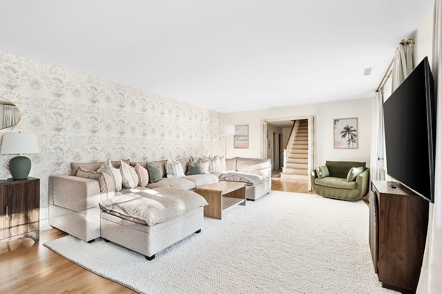 Unwind and relax on this large modular sofa, a velvet green swivel chair, blackout curtains for movies, and lots of lamp lighting.
