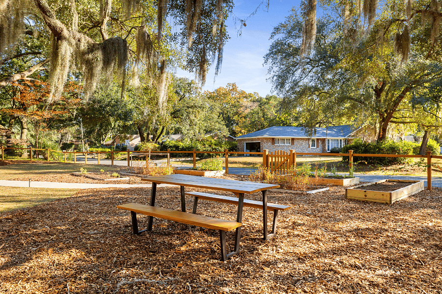 Fully fenced in front yard with a pcnic table to enjoy the beautiful Charleston weather and garden beds planted with herbs and wildflowers for your own entertainment.