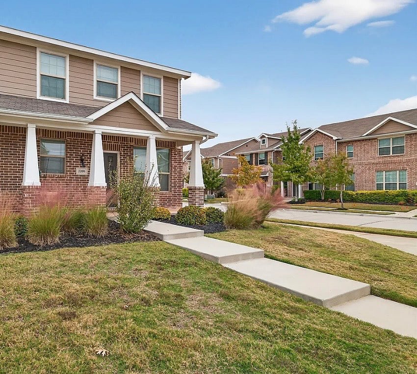 Townhouse exterior with large front porch, beautiful landscaping and sprinkler system.