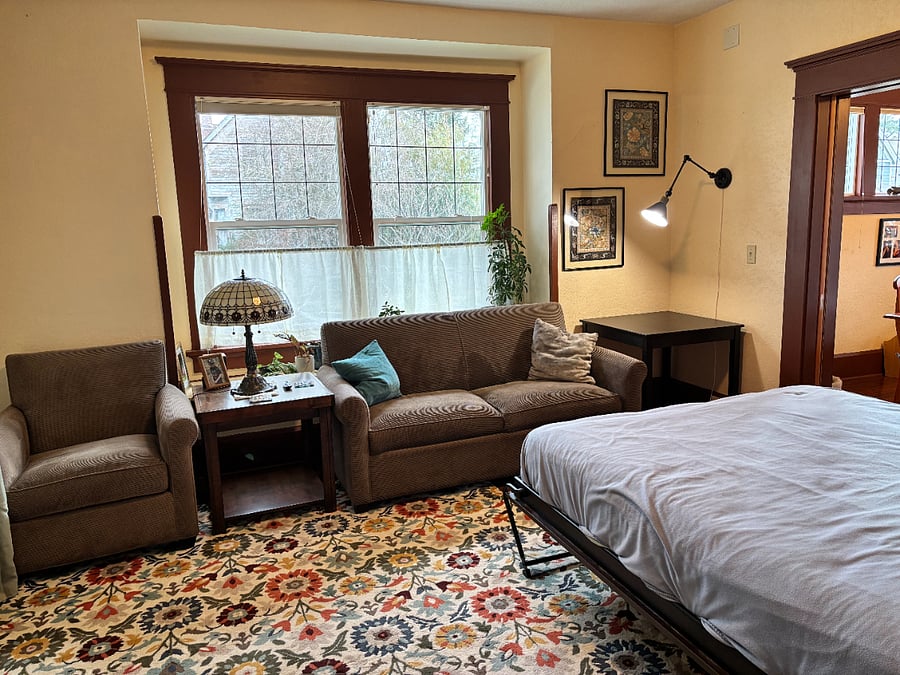 Your bedroom is large enough for a seating area. The smart TV is in a closet to the left.