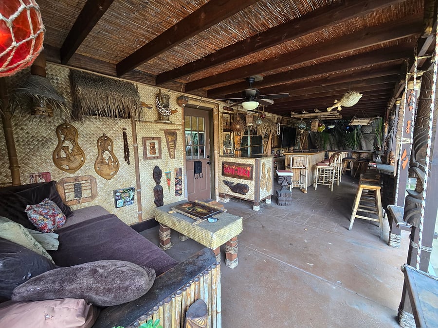 Tiki bar with TV and plenty of seating, and tons of ceiling fans