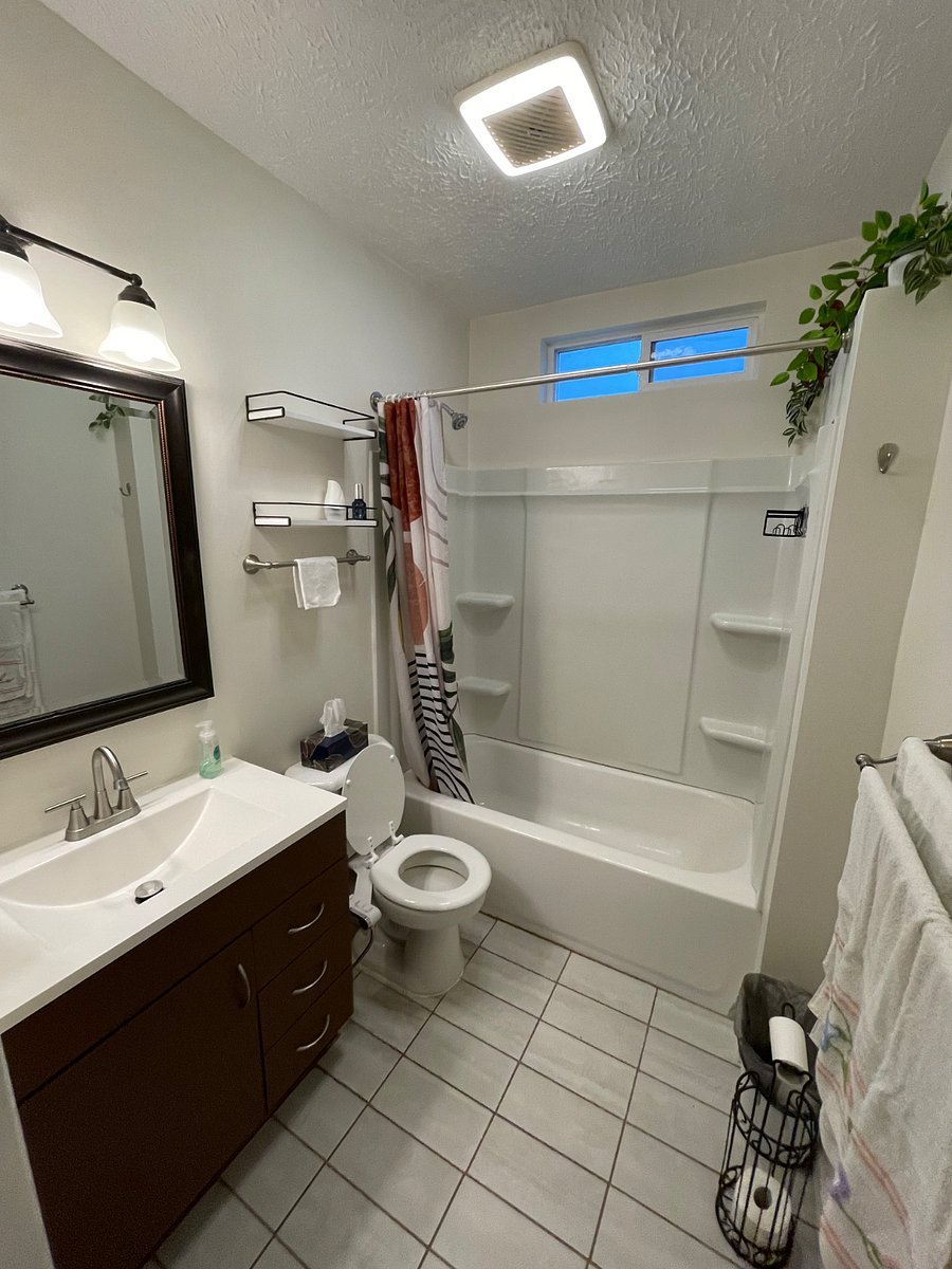 Bathroom with a bidet attachment on the toilet. 