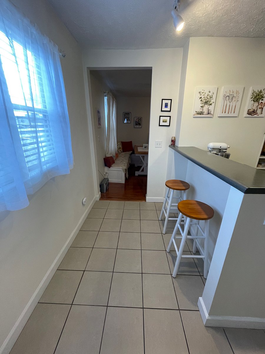 Bright kitchen with 2 barstools/bar.