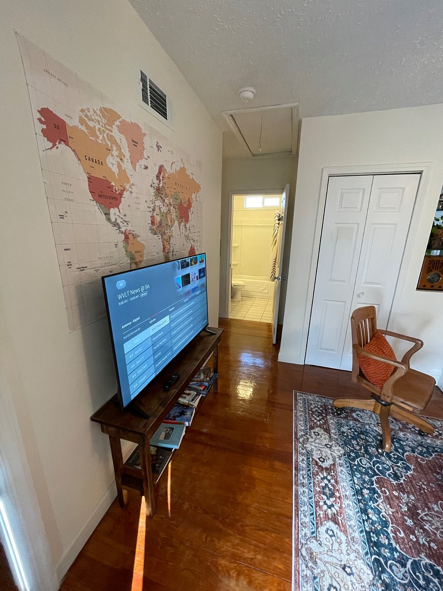 Front room/front bedroom closet behind TV / view into bathroom.