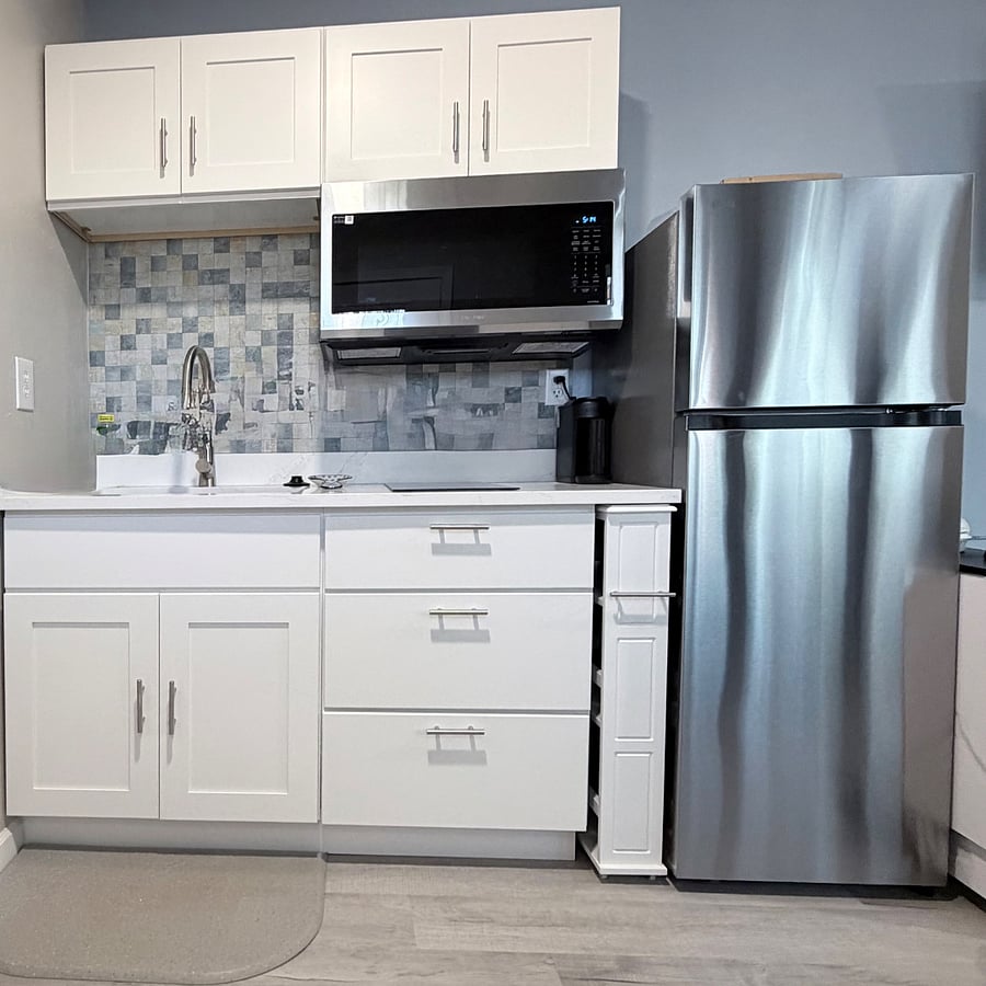 Kitchen equipped with large sink and dish rack, microwave/airfryer/oven, 2 burner stove, roll out pantry, garbage disposal, full size refrigerator