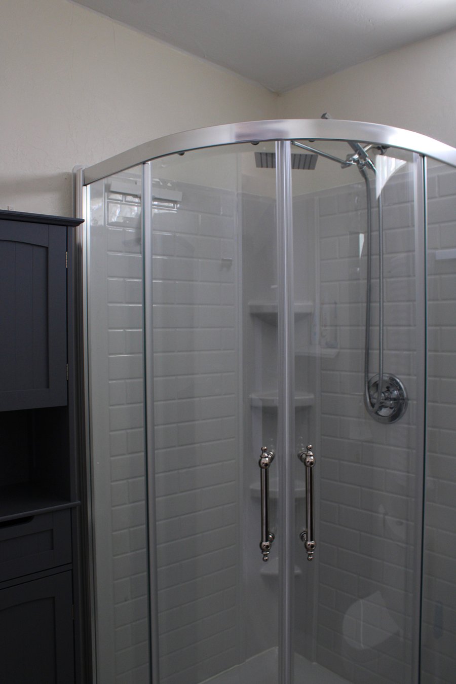 Corner shower and bathroom storage.
