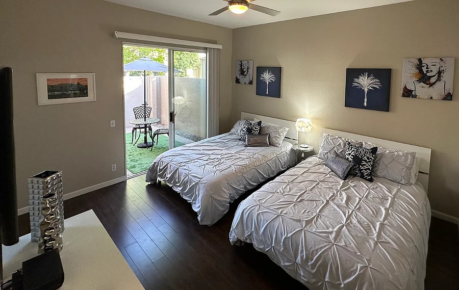 A breezy guest room with two cozy queens beds and its own private patio  guests will never want to leave