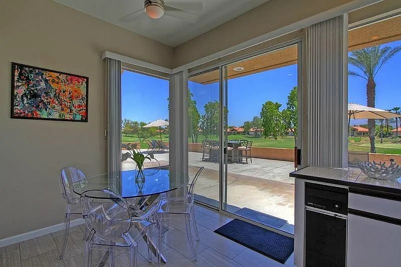 Morning coffee hits different at this sunlit breakfast nook with sliding doors that open right onto the golf course and wrap-around deck