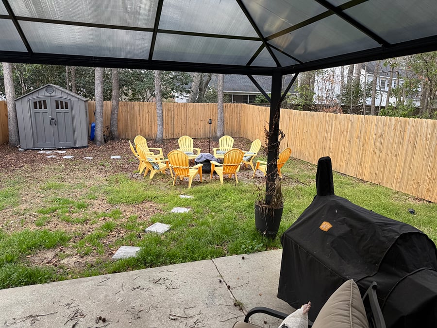 Grill and fire pit area in the fenced in back yard.