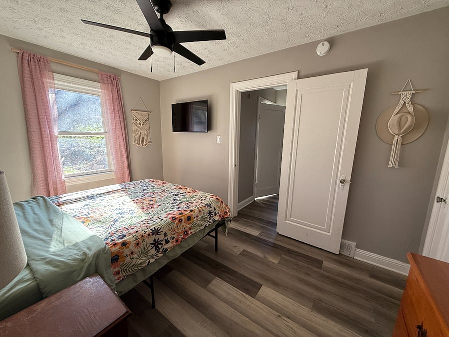 Bedroom w/ mounted TV.