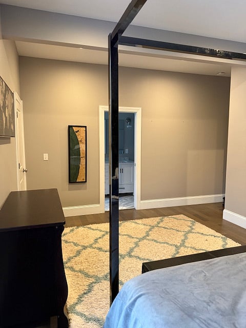 View shows: door on left to sunroom, center door is bathroom, hallway to right includes door to walk-in closet and door to hallway.