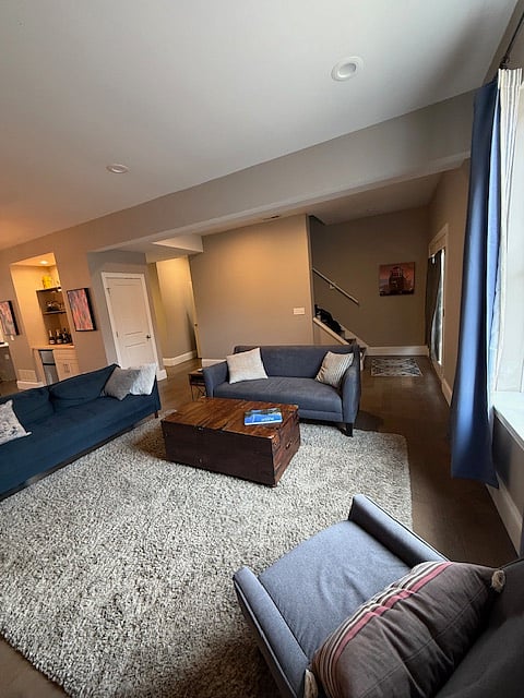 Living room: view includes front doors, stairs to upper level, dining room to left.