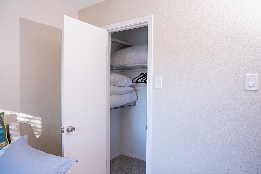 Third bedroom walk-in closet with plenty of shelves and hanging space. Bedding for trundle also in closet.