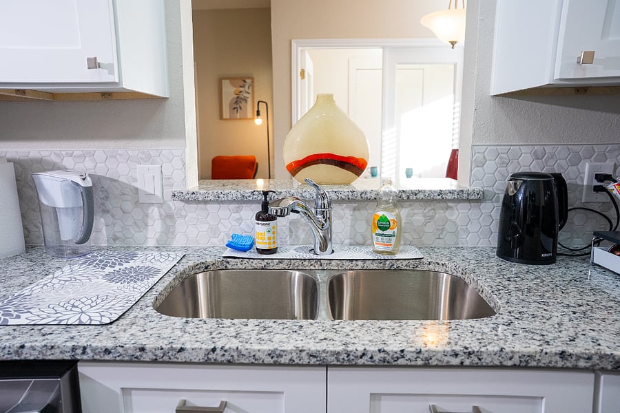 The kitchen and laundry area are stocked with clean, eco-friendly cleaning products for dishes, laundry, and general household use.