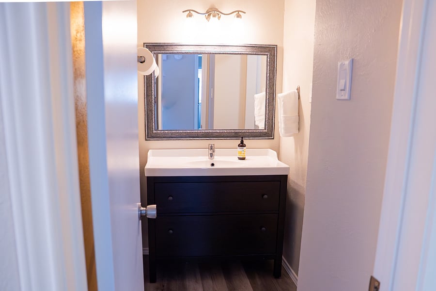 The hallway bathroom is updated, clean, and spacious, stocked with essentials including shampoo, conditioner, body wash, fresh towels, paper towels, and toilet paper.