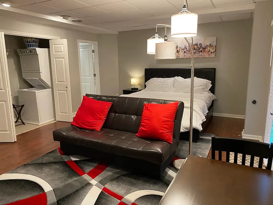 Master Bedroom with King bed, washer/dryer utilities (stacker) in the closet (doors can be closed), artistic reading lamp and comfortable folding-brown sofa (can lay flat to create a futon for a full-size bed/trifold-topper mattress pad in the closet).