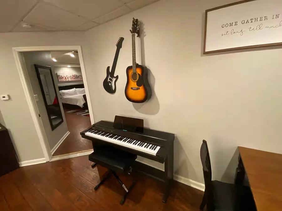 Yamaha 88 key weighted-action piano keyboard, acoustic guitar hung on the way (the electric-guitar is an artistic-design piece, not playable)
To the left is the entrance door to the Master bedroom.