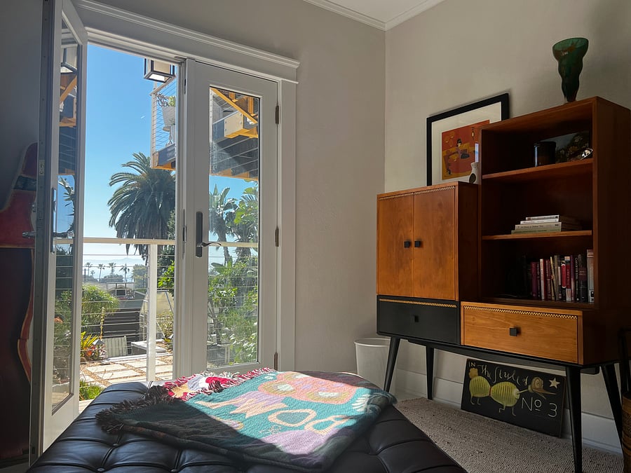 Third bedroom with leather chaise instead of twin bed. Outdoor balcony with two chairs includes an ocean view. The room also has a large closet.