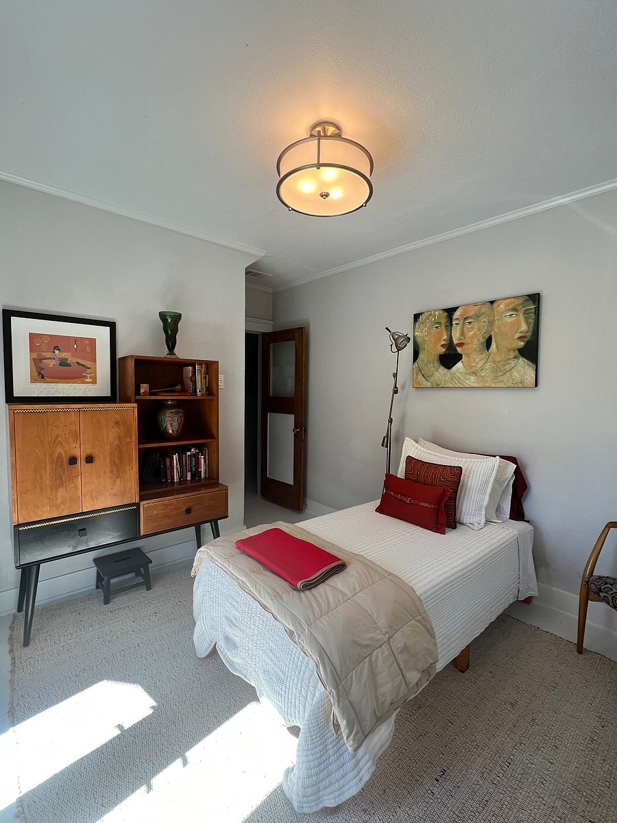 Third bedroom with twin bed. Outdoor balcony with two chairs includes an ocean view. The room also has a large closet.