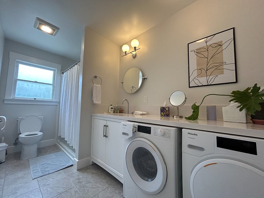 Bathroom features a rain shower and an in-unit washer and dryer