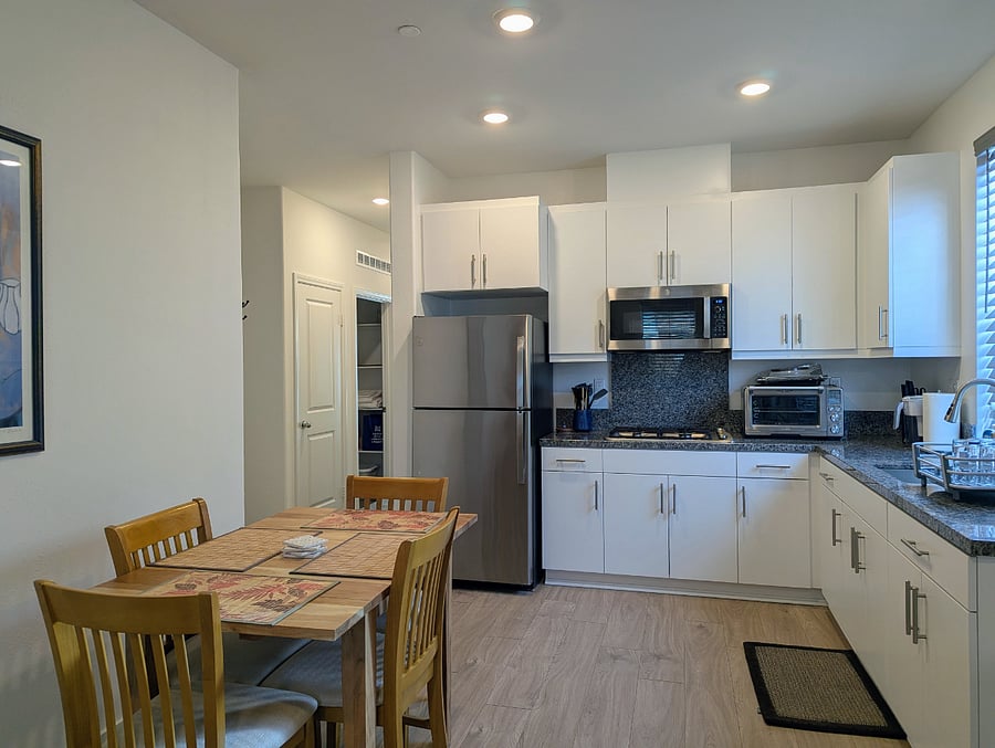 Well-appointed kitchenette with full-sized fridge, gas cooktop, microwave, oven/air fryer combo. Extendable dining table with seating for 2-4.