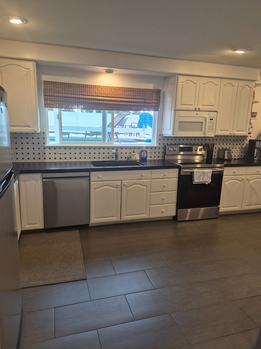 Dishwasher, stove, microwave, coffee pot, toaster, spices above stove