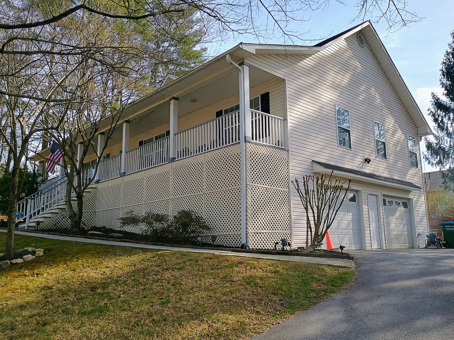 Side view of the house showing the garage, with multiple parking spaces available on the driveway and one parking spot inside the garage.