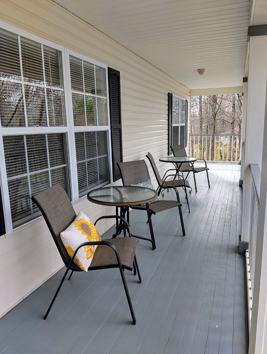 The cozy porch offers plenty of seating for relaxing and enjoying the surroundings, along with dawn-to-dusk light fixtures.