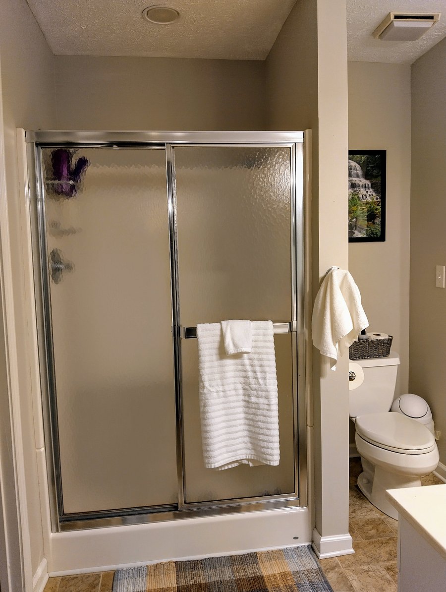 The primary bathroom features a shower stall.