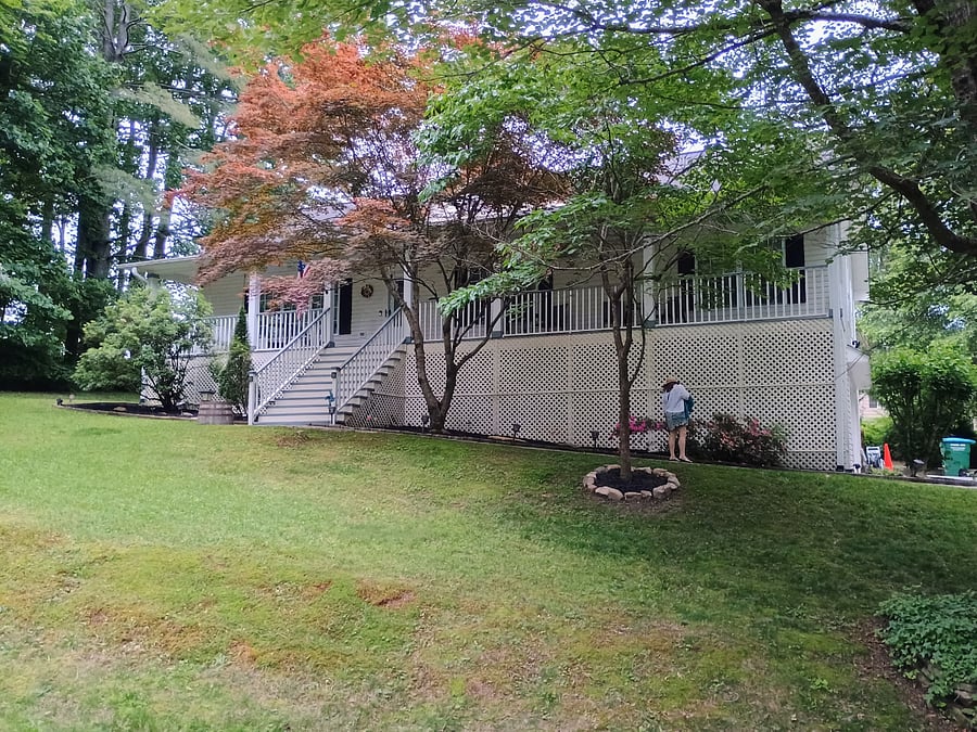 Front view of the house and its cozy, welcoming porch in the summertime.