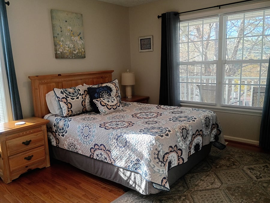 The secondary bedroom, known as the "Blue Room," features a queen-size bed, a desk and chair, and a cubby for clothing or personal items.