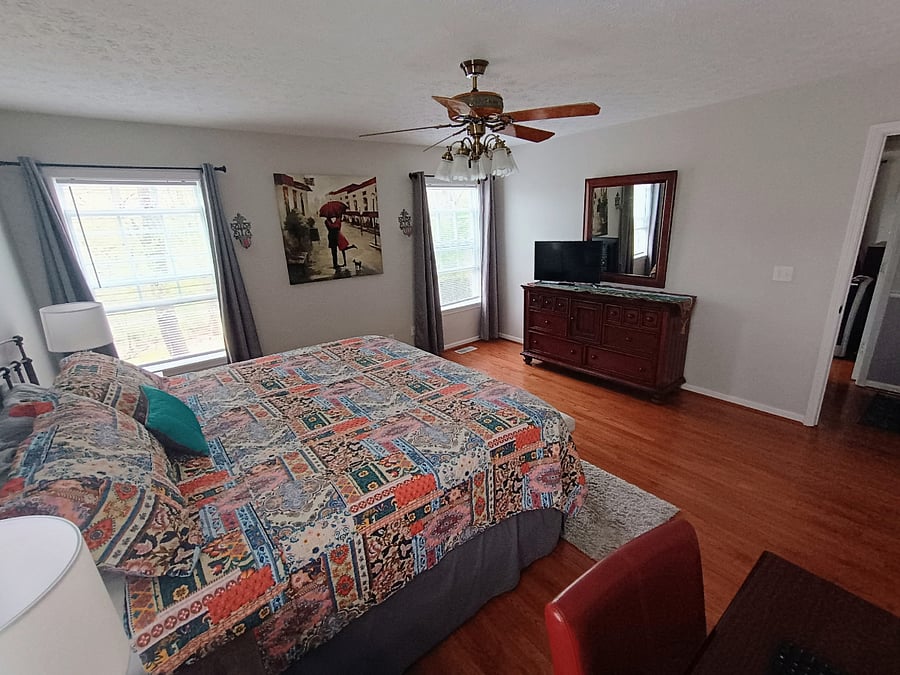 The primary bedroom includes a small Smart TV that sits on the dresser, offering a cozy option for winding down.