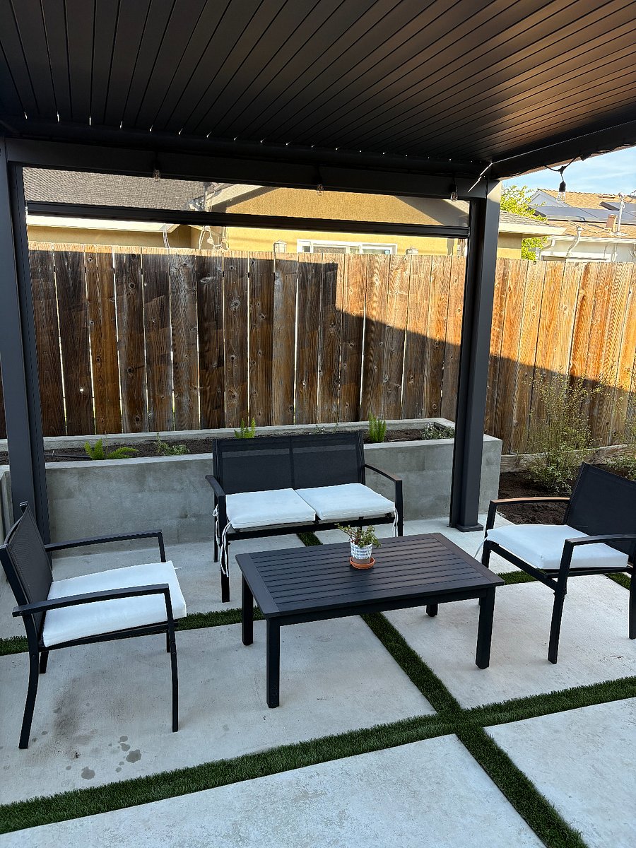 This is a shared backyard space that features a pergola with outdoor patio furniture and outdoor string lights to lounge and relax. Pergola comes with rooftop shades that can open or close to let sunlight in.