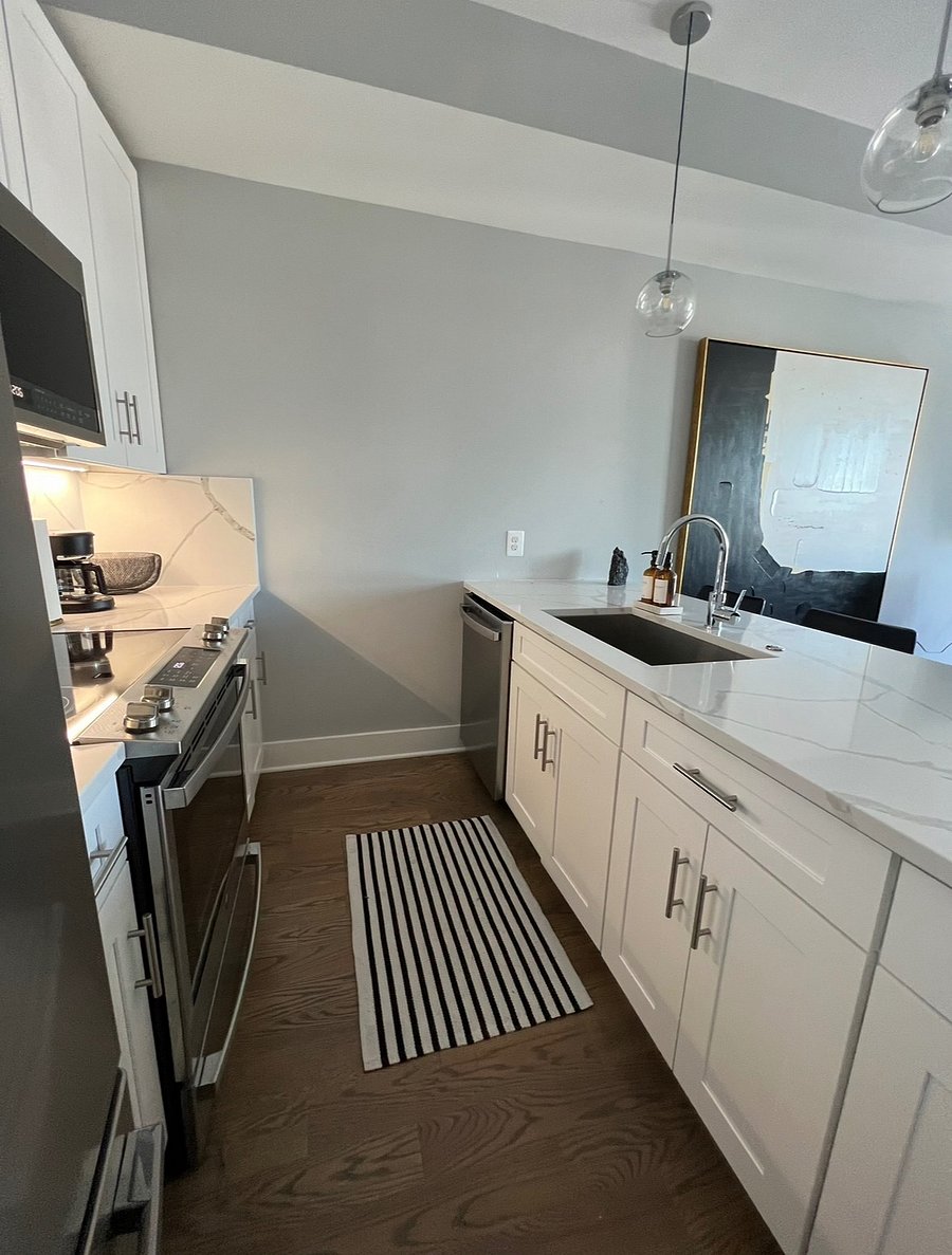 The kitchen features a dishwasher, electric stovetop and oven and a full-sized refrigerator. 