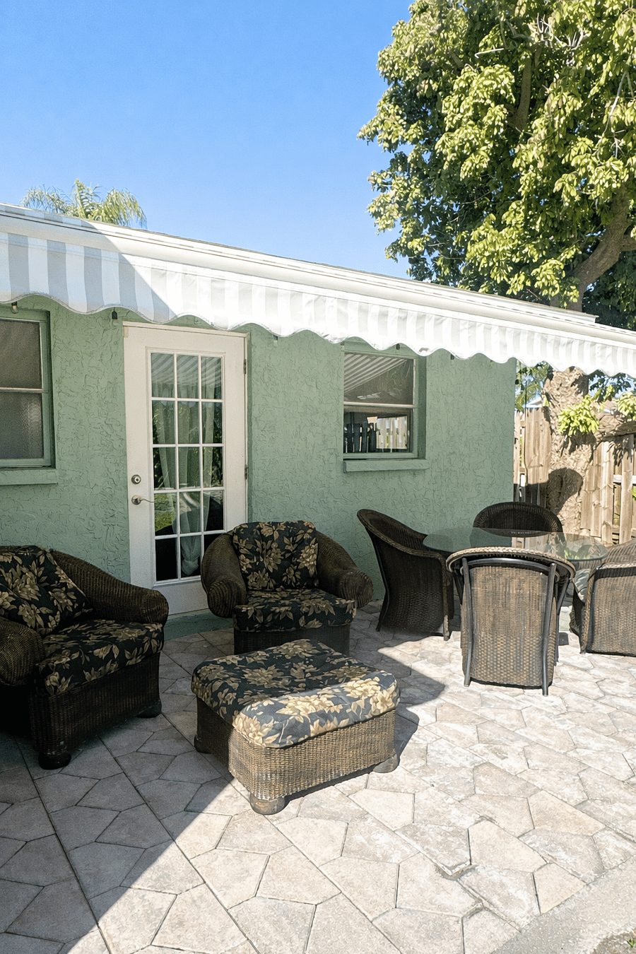 Private outdoor patio with comfortable seating and a dining table, perfect for relaxing, dining al fresco, and enjoying the Florida sunshine.