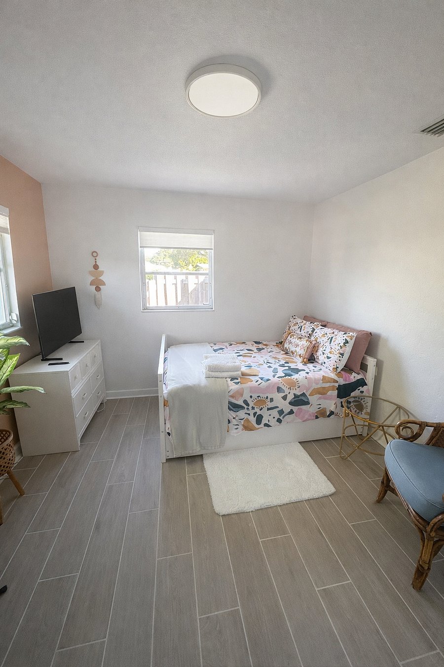 Bright guest bedroom with a comfortable bed, smart TV, and cozy dcor. A welcoming space to relax and unwind during your stay.