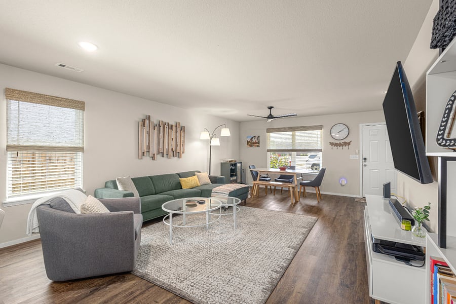 The open concept living room features comfortable seating and a multi-use dining area.