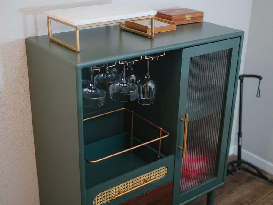The bar cart contains wine glasses, games, and additional storage.