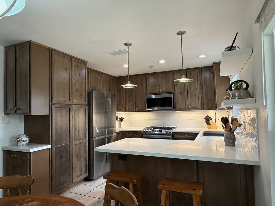 Open and fully equipped kitchen featuring wood cabinetry, spacious countertops, and a large sink area for comfortable light cooking.