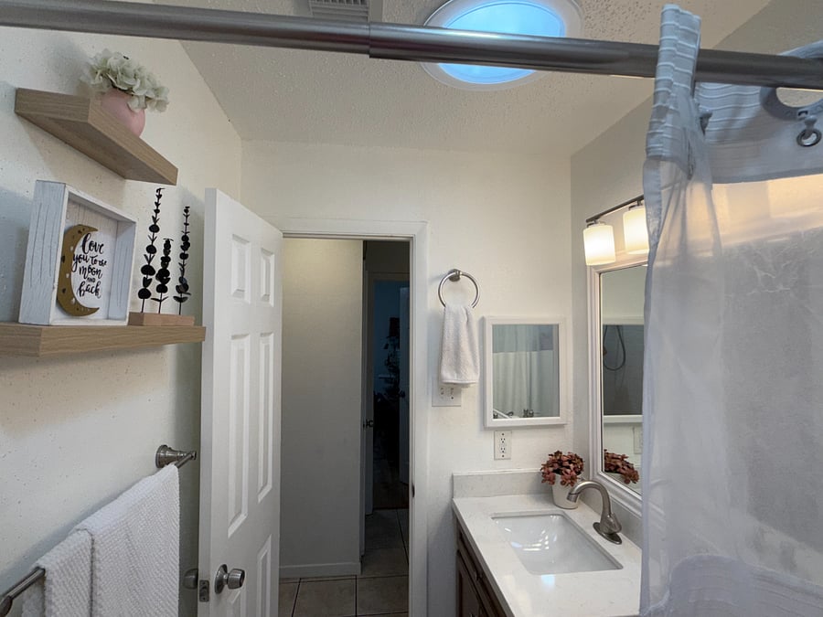 Resident bathroom includes natural light, tub/shower combination, fresh towels, toiletries, and everyday essentials.
