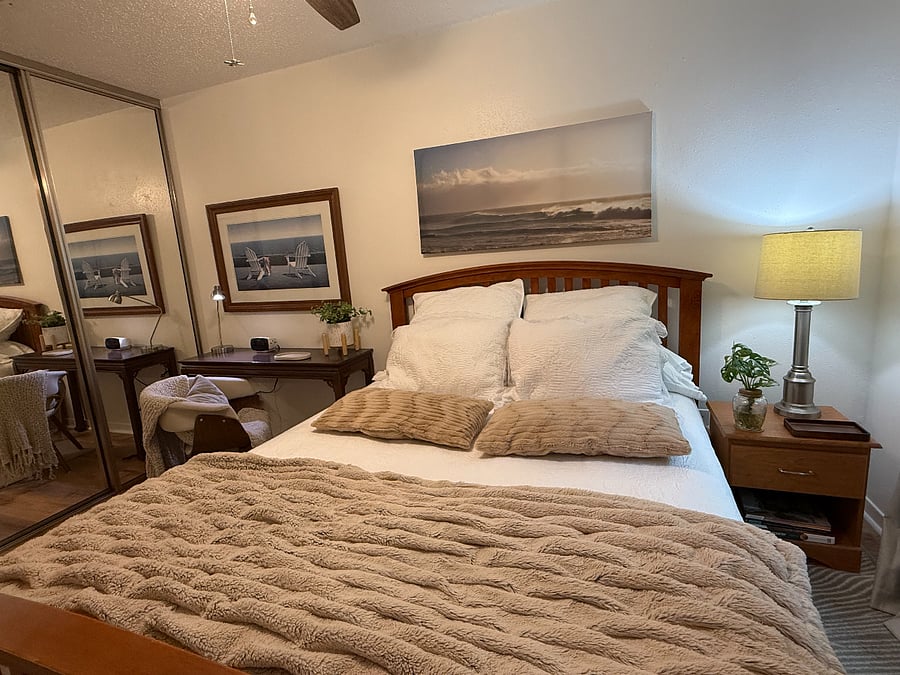 Comfortable queen-size bed with soft linens and newly installed smooth-gliding mirrored closet doors.