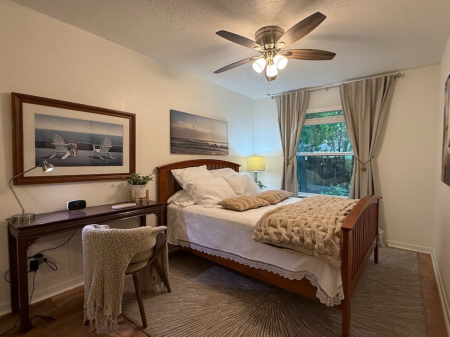 Quiet bedroom with insulated double-pane windows, adjustable blinds, and blackout thermal curtains for added privacy, comfort, and noise reduction.