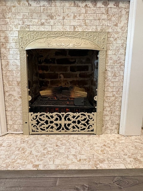 Faux fireplace emits heat with a remote control and has a sound gadget.