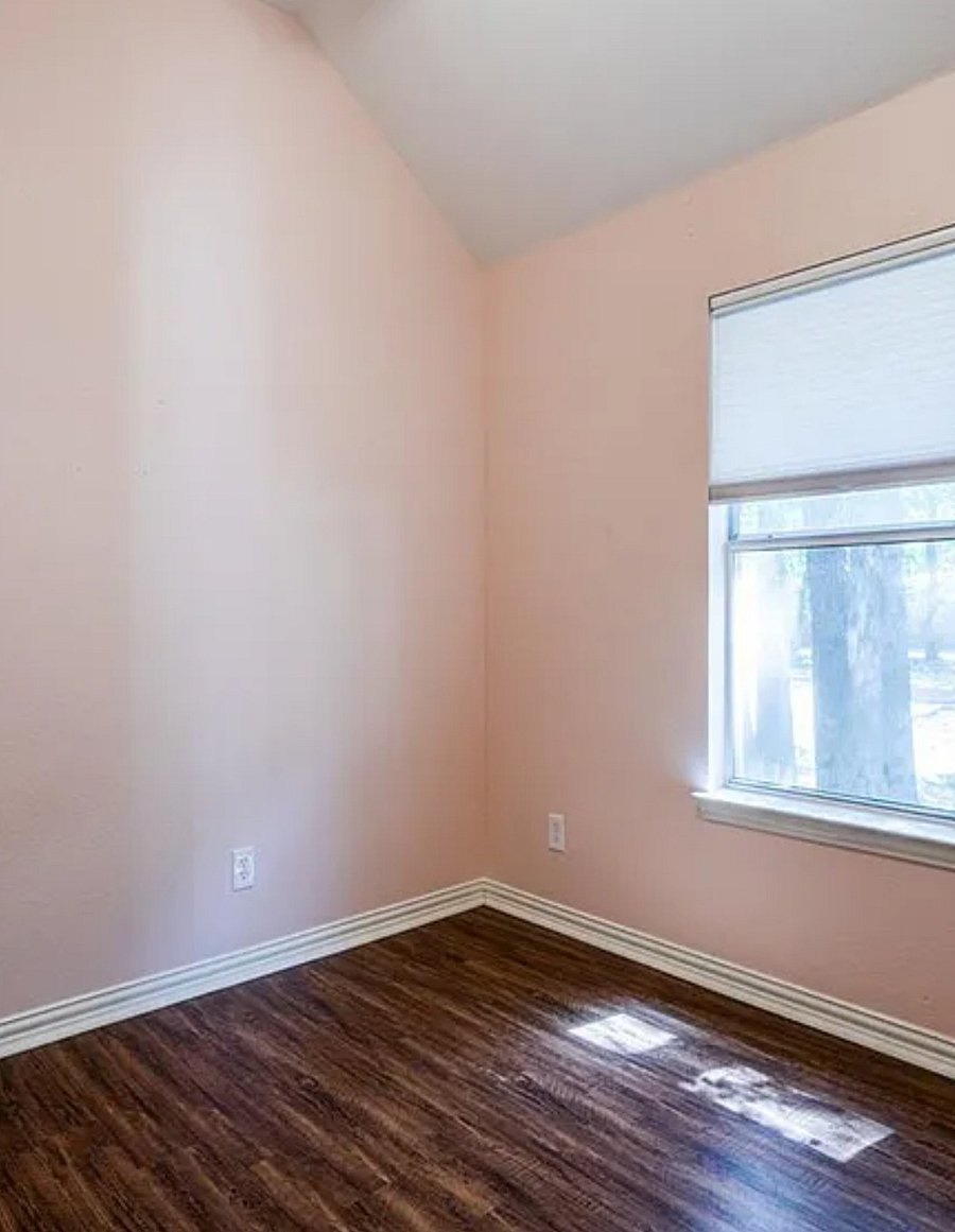 Bedroom with windows. There is a twin bed and dresser drawyer desk and closet space. Mounted TV