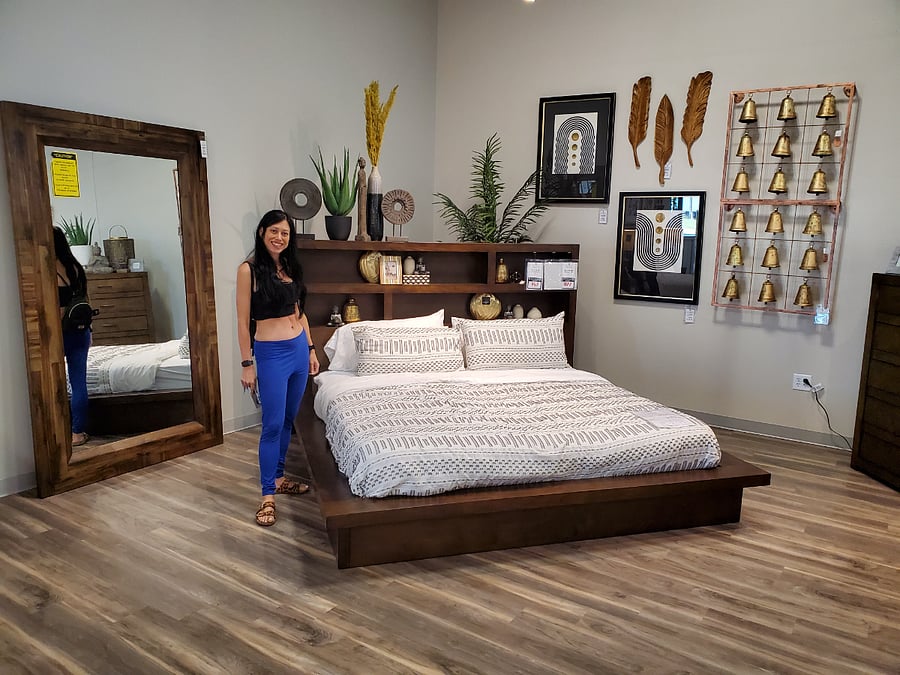 Master bedroom. Bed with headboard shelving with large freestanding mirror.
