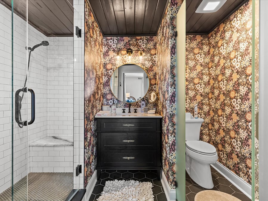 Primary private bathroom with sit down bench, rain shower head and secondary hand held.