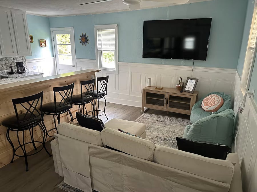 Large smart TV in kitchen/living area with bar seating.