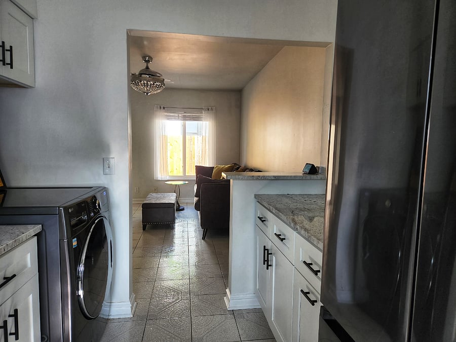 Kitchen with full size refrigerator and all-in-one LG washing machine